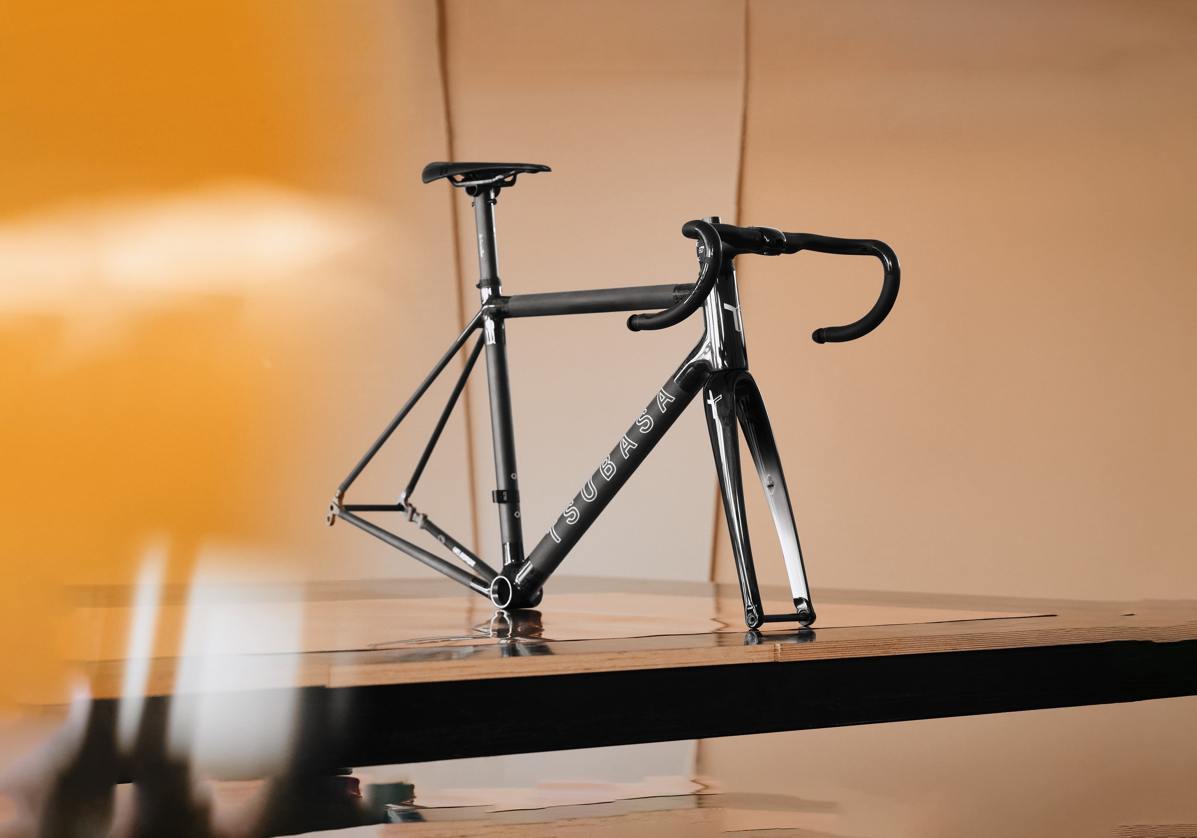 A Tsubasa Crow frameset and fork, studio-lit on a warm ground