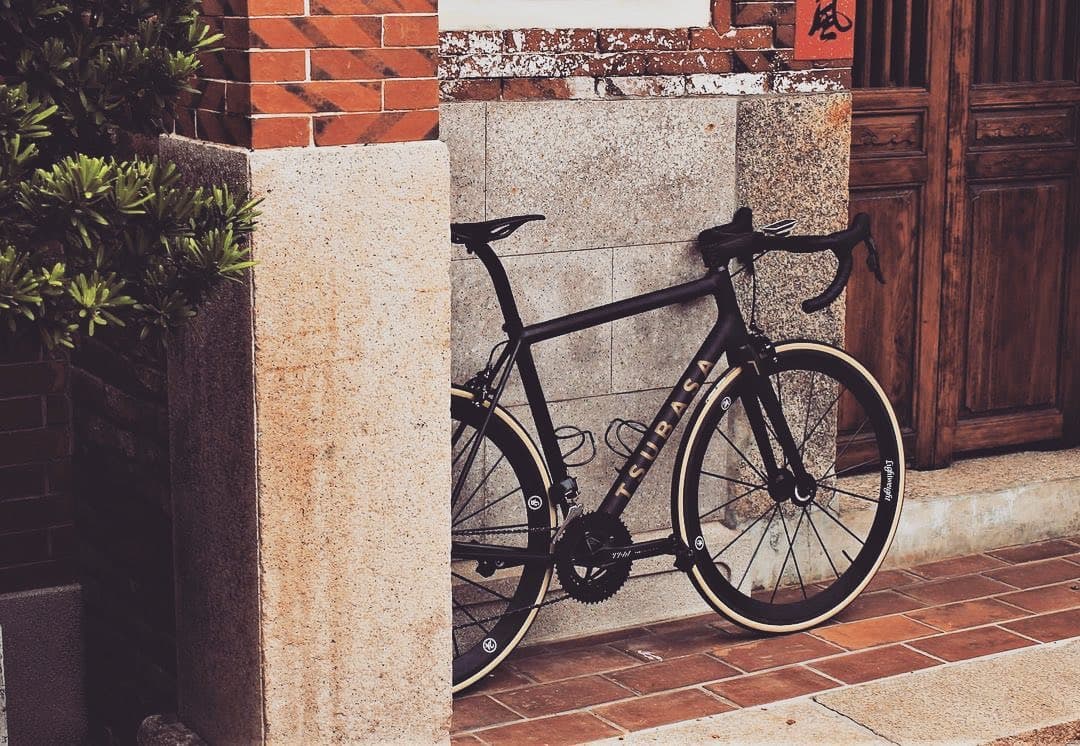 A bike propped against a stone wall beside an old wooden door