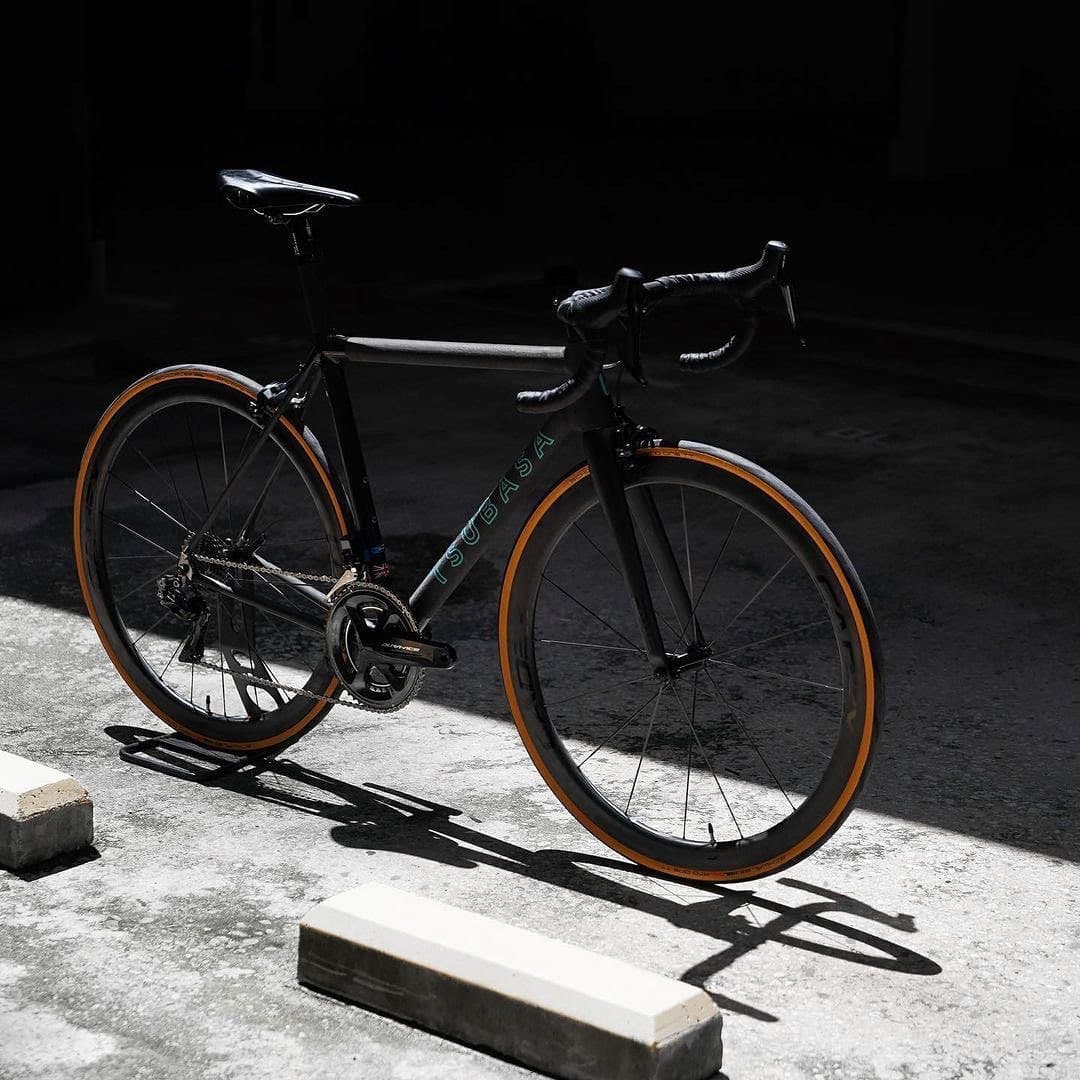 A frame on tan-walled tyres, side on, lit against a dark street