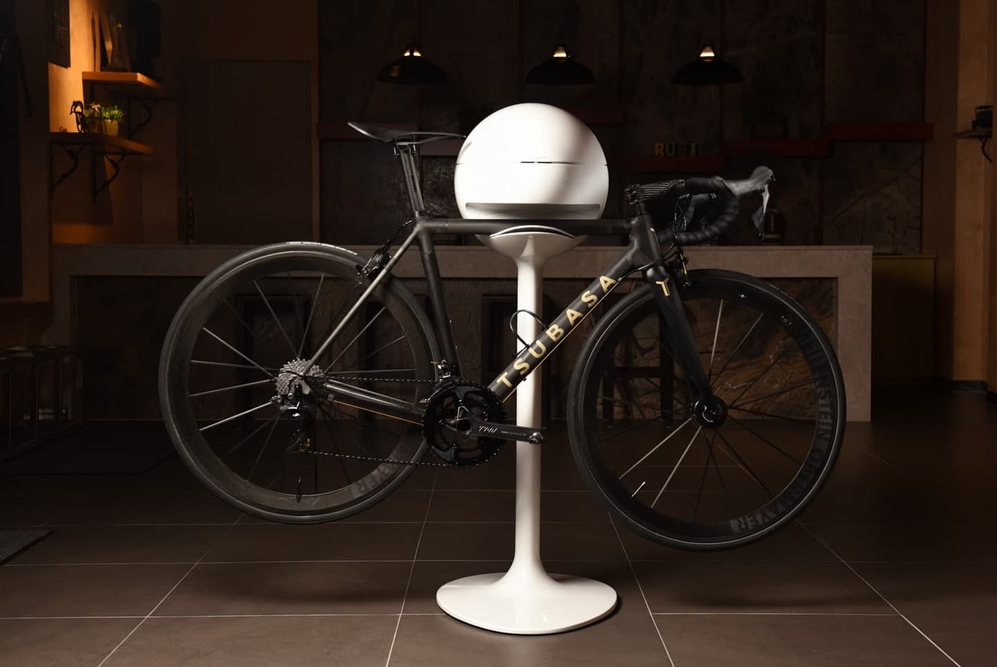 A bike on a stand in a warm interior, lit from above