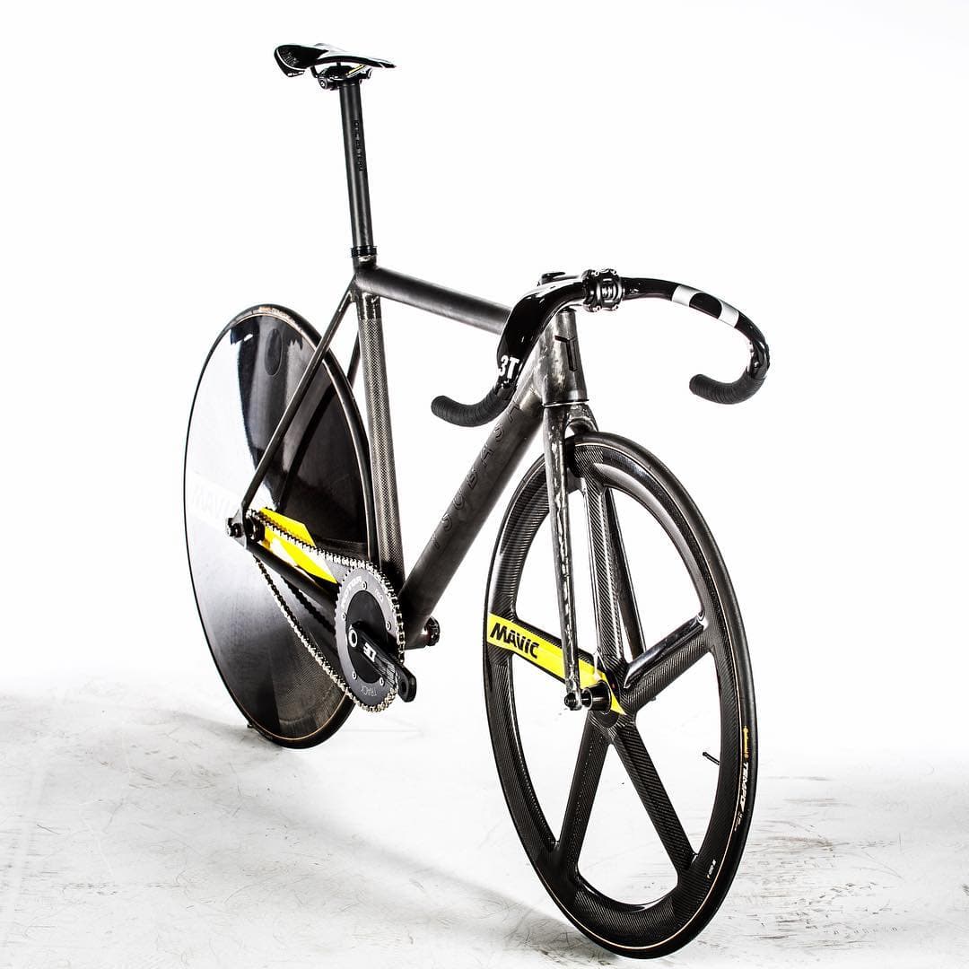 A track bike on a white ground, disc rear wheel