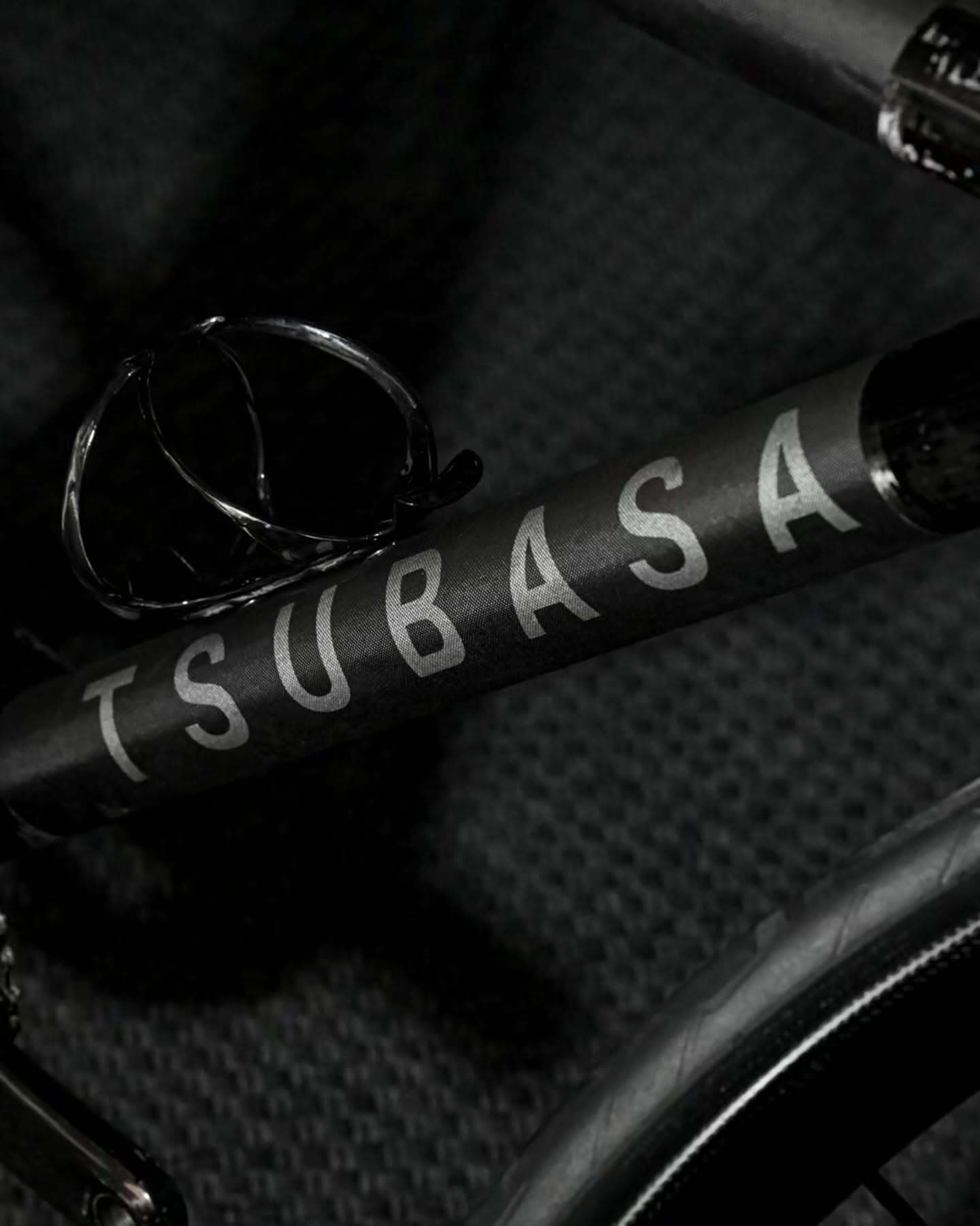 The down tube close in, the TSUBASA wordmark catching the light against black
